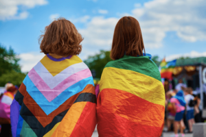 two teens supporting each other at a pride rally