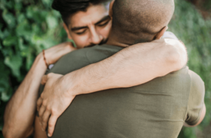 men hugging and embracing each other after learning that one suffers from severe trauma, and deciding to sign up for trauma therapy in Simi Valley, ca