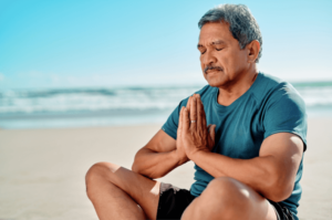 man practicing breathing exercises and trying to ground himself to cope with stress through this exercise he learned in anxiety therapy in Simi Valley, ca