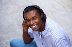 young man feeling happy listening to music and discovering that to be a wonderful coping tool thanks for therapy for trauma