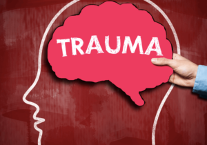 the word trauma on a brain being help up by a therapist in simi valley for trauma therapy